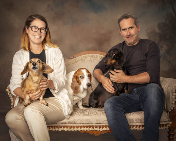 A picture of Christy, Mike, and the pups on a couch